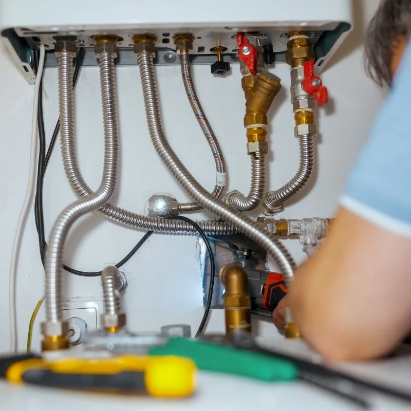 Elevate Plumbing expert connecting flexible stainless steel water lines and brass isolation valves during a professional tankless water heater installation in a Park Ridge home.