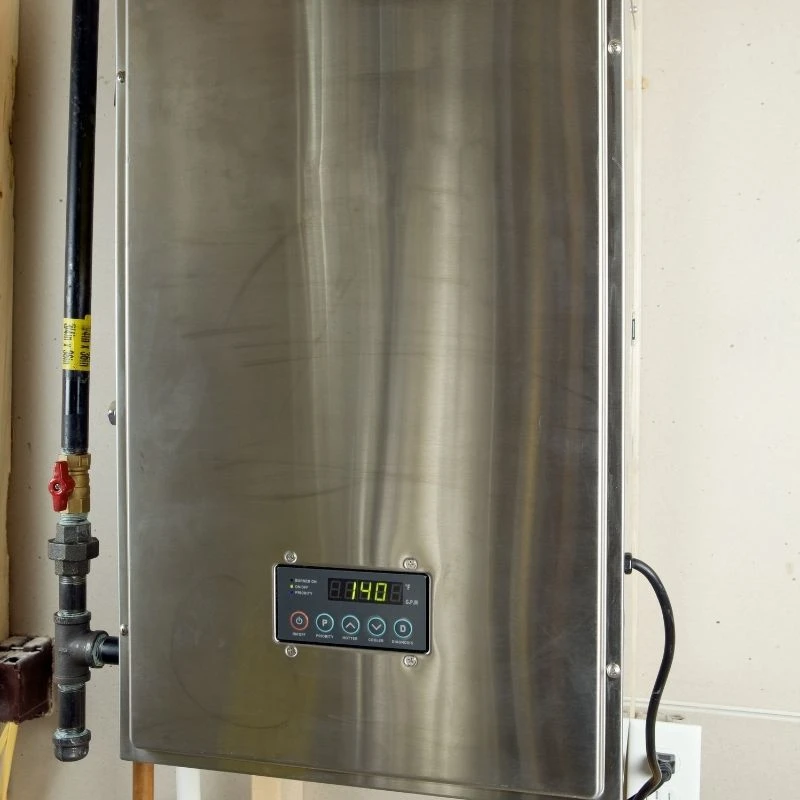 High-capacity stainless steel tankless water heater mounted on a basement wall with a heavy-duty black iron gas line for endless hot water in Park Ridge.