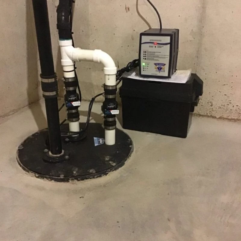 Professional installation of a Pro Series battery backup sump pump and dual discharge system with check valves to protect a finished basement in Park Ridge.