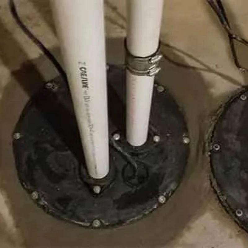 Securely sealed sewage ejector pump pit cover with a dedicated vent line and clamped discharge pipe to safely process basement bathroom waste in Morton Grove.