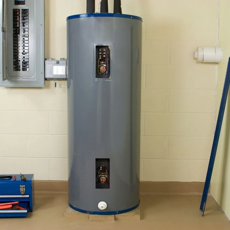 Traditional residential electric water heater with open access panels during a routine thermostat repair and tank maintenance service in a Niles basement.